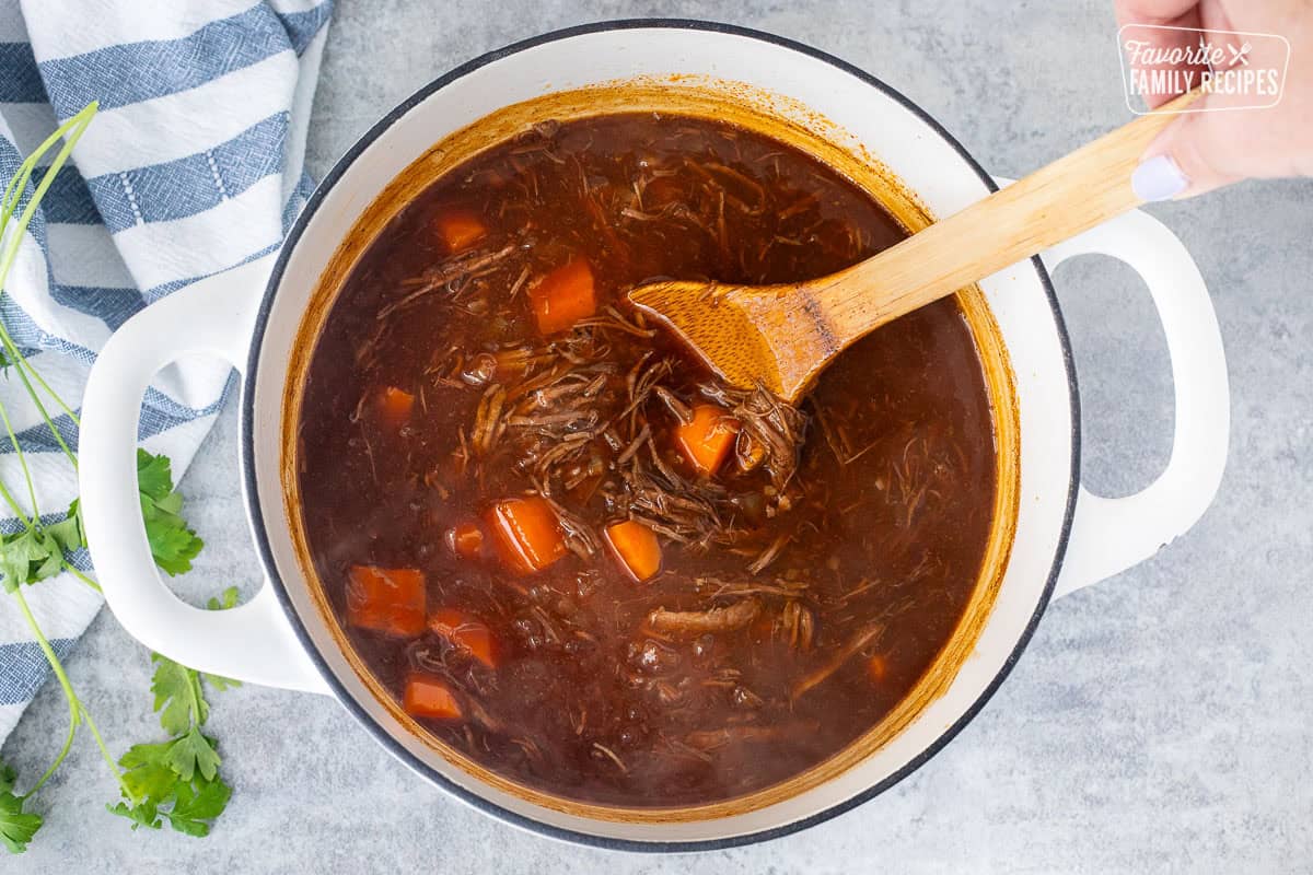 Stirring beef goulash to thicken.