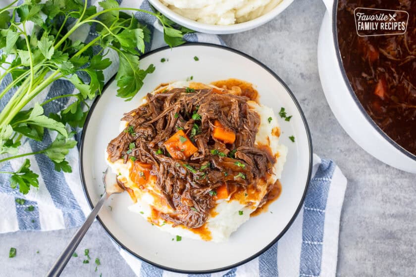 Plate of beef goulash over mashed potatoes.