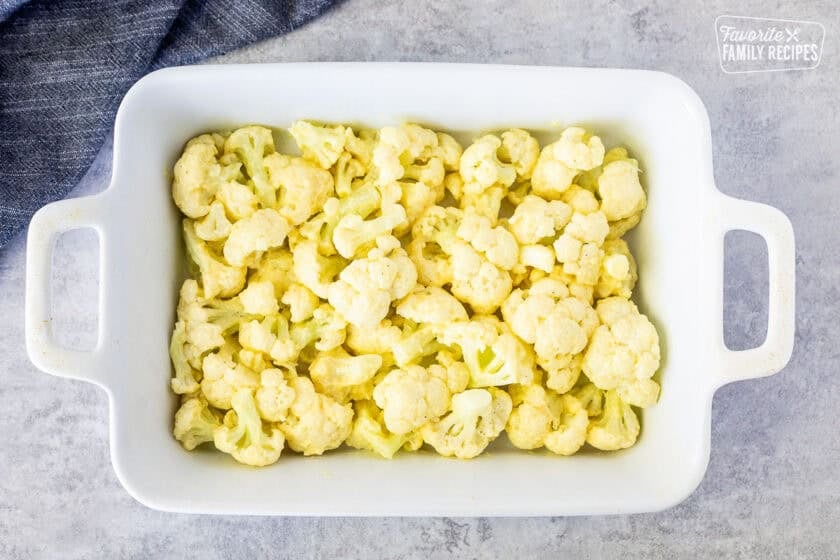 Baking dish with cauliflower mixed with sauce.