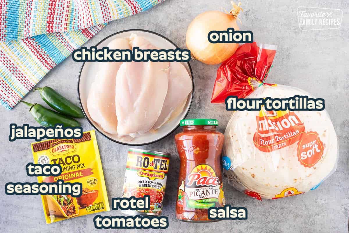 Ingredients to make crockpot chicken tacos including soft tacos, salsa, diced tomatoes with green chilies, onion, chicken, taco seasoning and jalapeños.