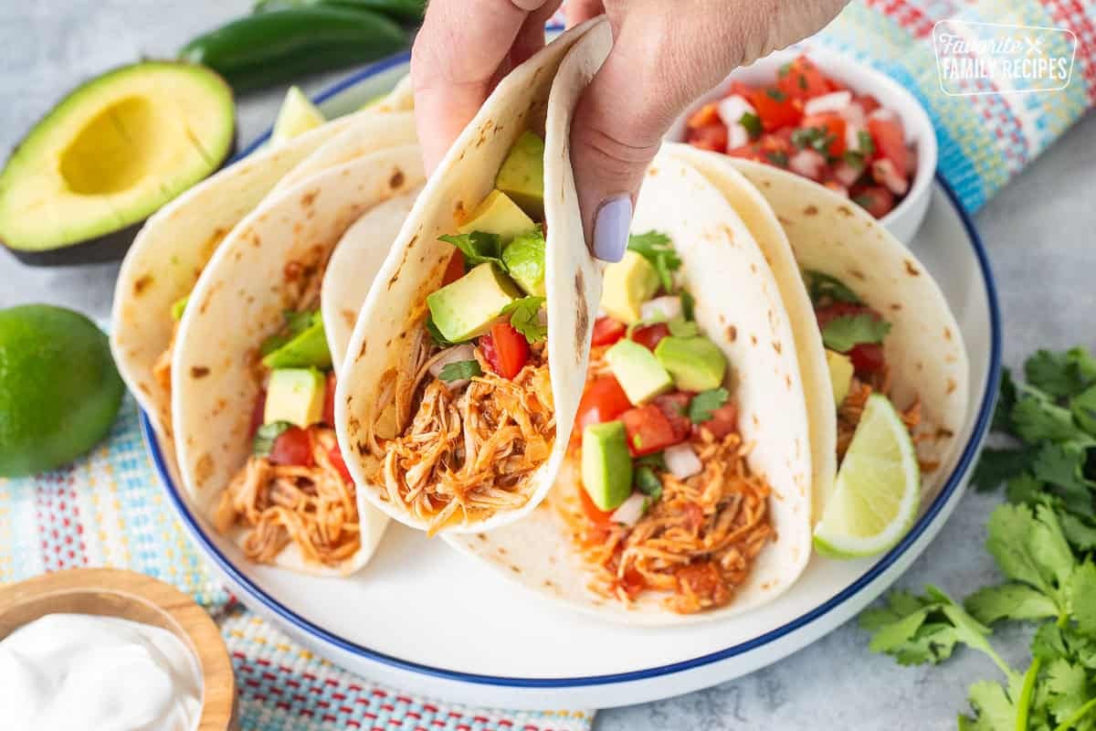 Holding a crockpot chicken taco in hand.