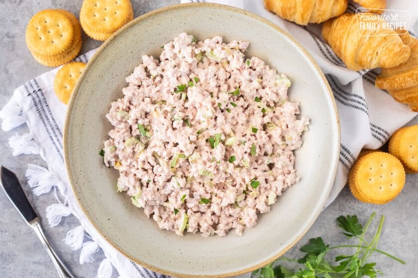 Ham Salad in a bowl with crackers and croissants on the side.