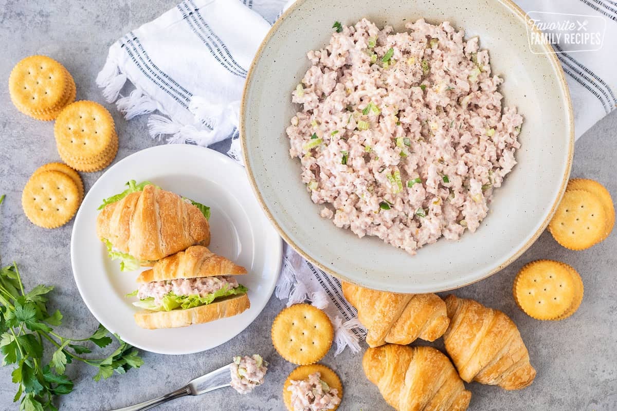 Ham Salad in a bowl with crackers and croissants on the side.