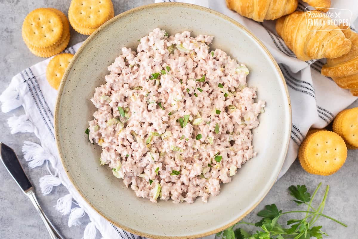 Ham Salad in a bowl with crackers and croissants on the side.