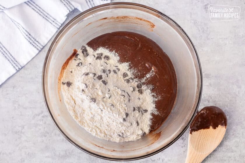 Glass mixing bowl with dry ingredients added to wet ingredients.