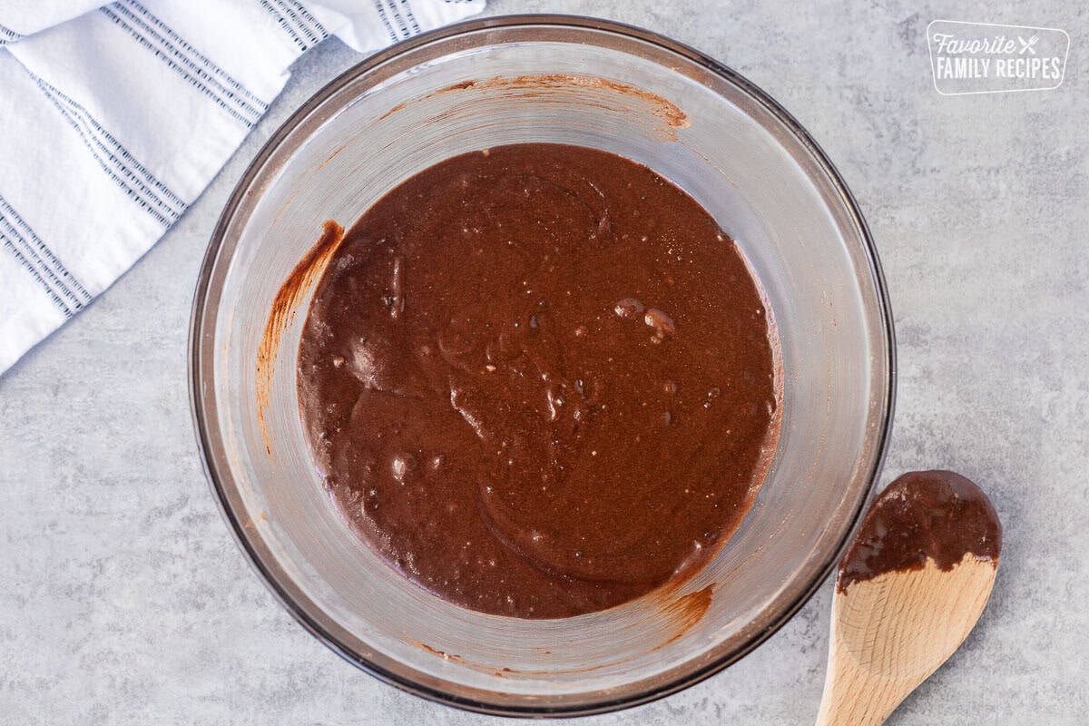 Glass mixing bowl with brownie wet ingredients mixed.