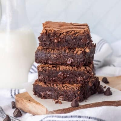 Stacked pile of homemade brownies with a glass of milk.