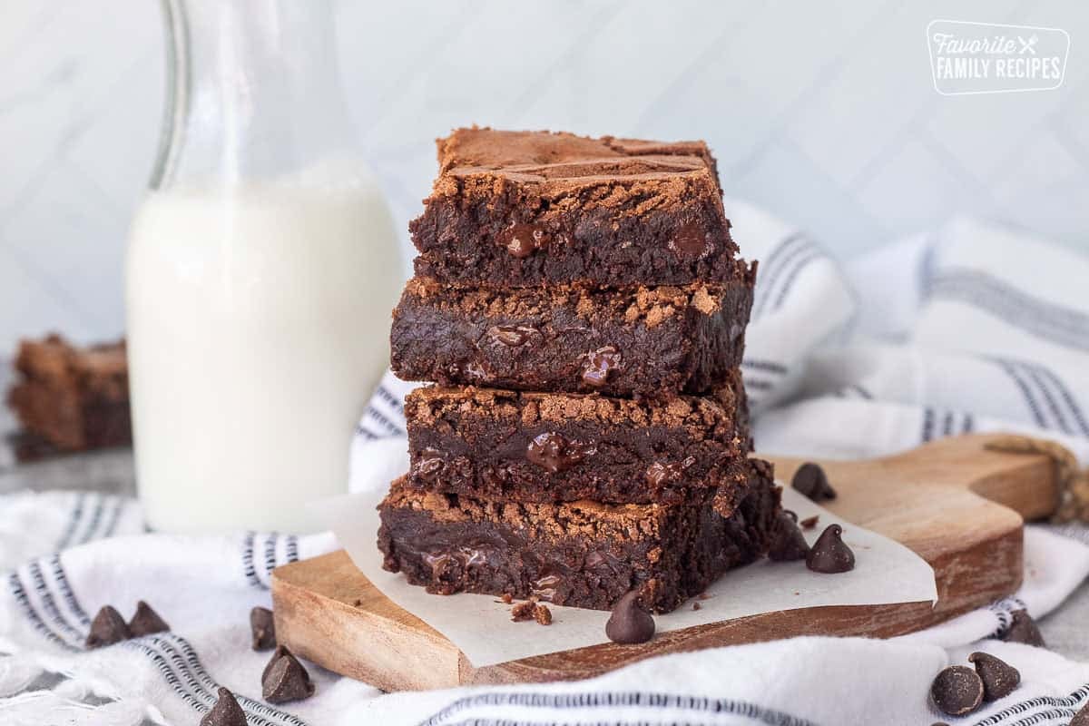 Stacked pile of homemade brownies with a glass of milk.