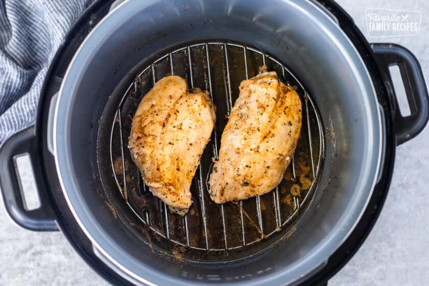 Cooked chicken breasts in an instant pot on a trivet.