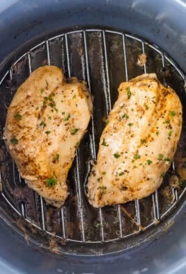 Two cooked chicken breasts in an instant pot on a trivet.