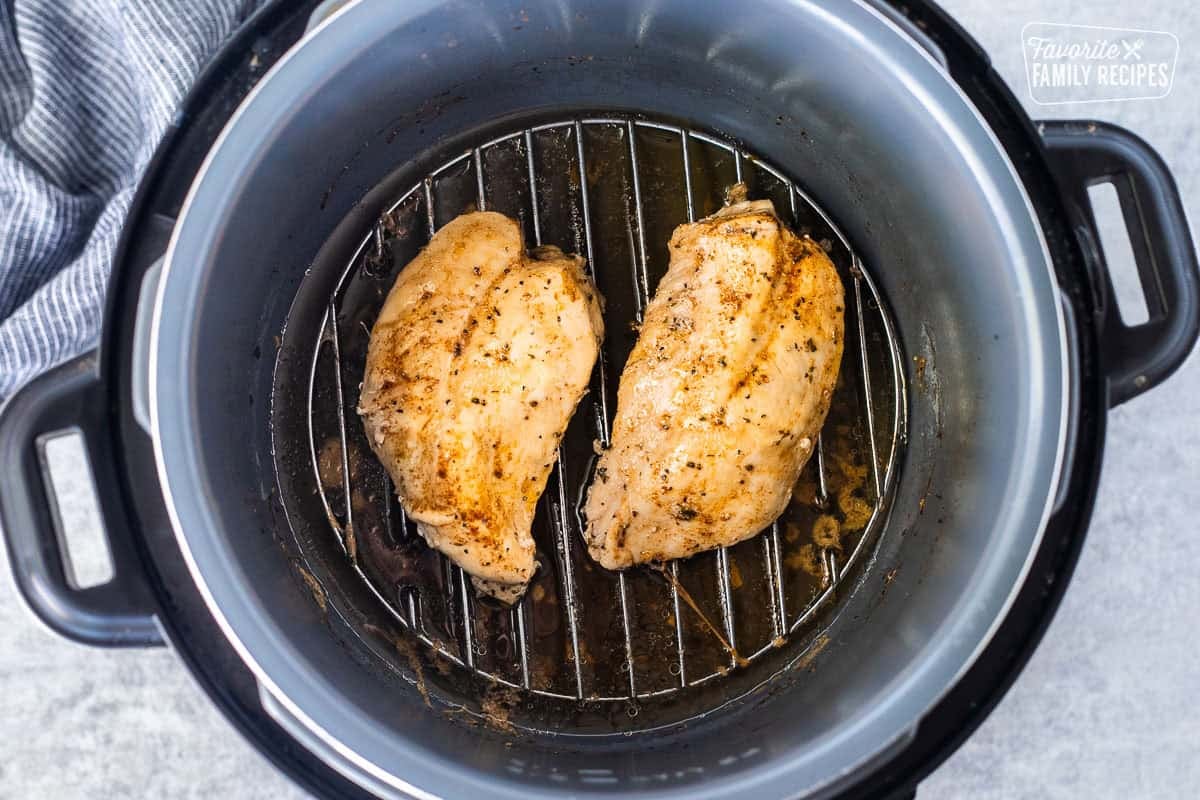 Cooked chicken breasts in an instant pot on a trivet.