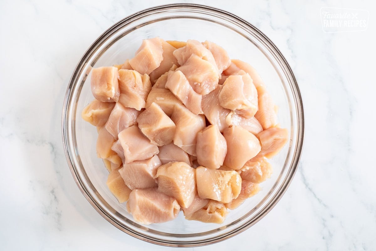 Glass bowl with cut chicken breasts.
