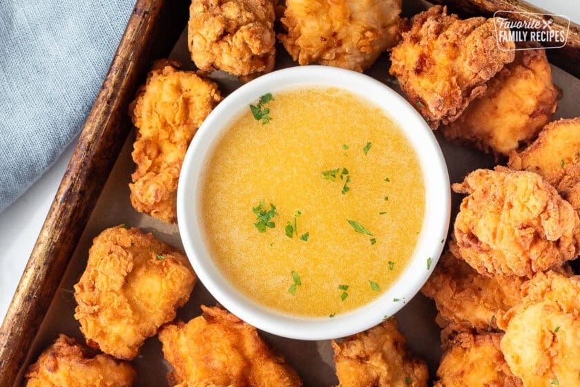 Dipping sauce for Mafa chicken surrounded by chicken.