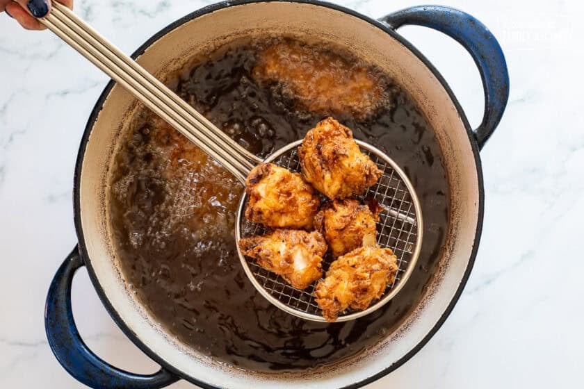 Frying Mafa Chicken in a large dutch oven of oil.