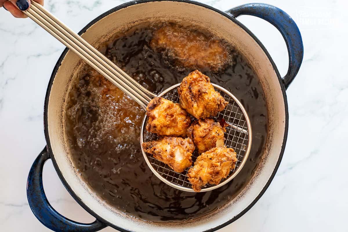 Frying Mafa Chicken in a large dutch oven of oil.