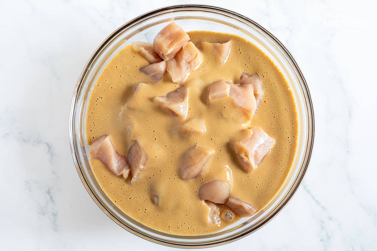 Glass bowl with chicken pieces marinading.