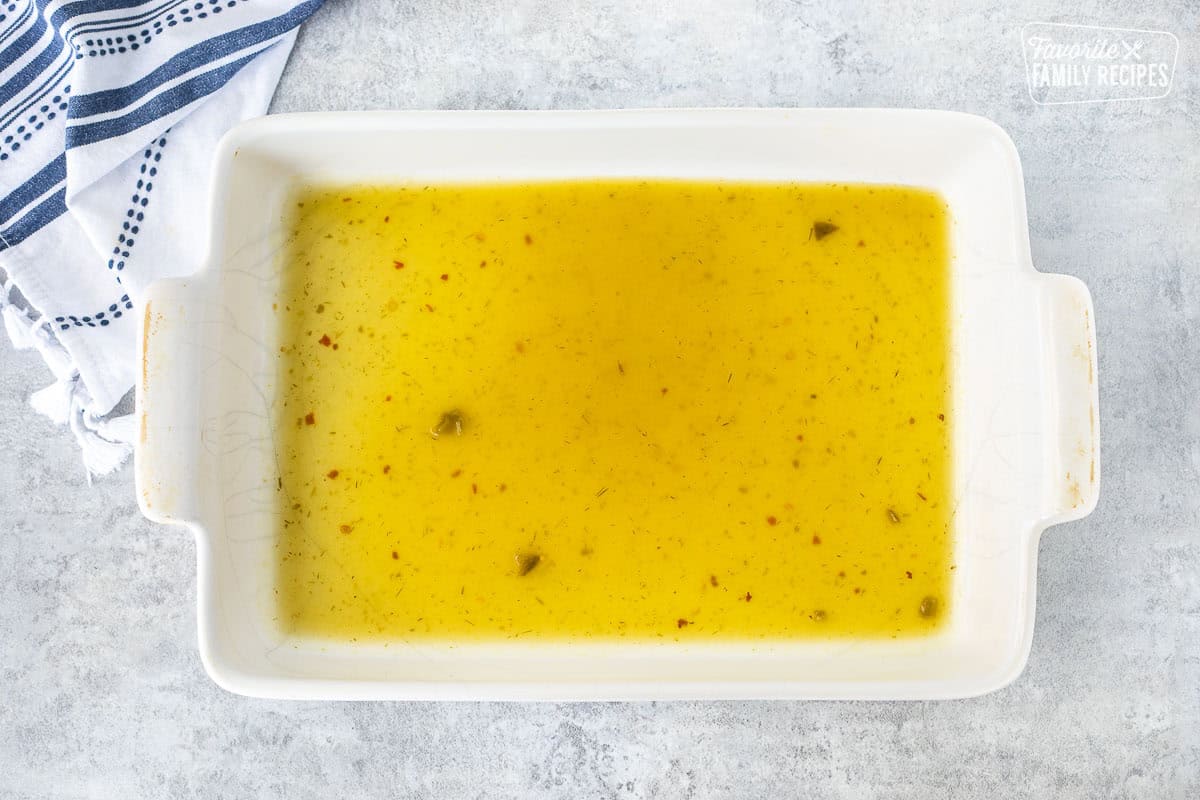 Baking dish with enchilada sauce in the bottom.