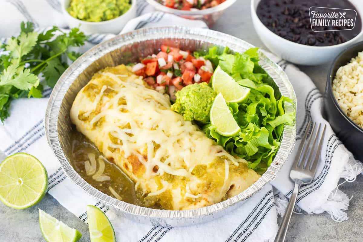 Sweet pork burrito with chopped lettuce, pico de Gallo, guacamole and lime wedges.