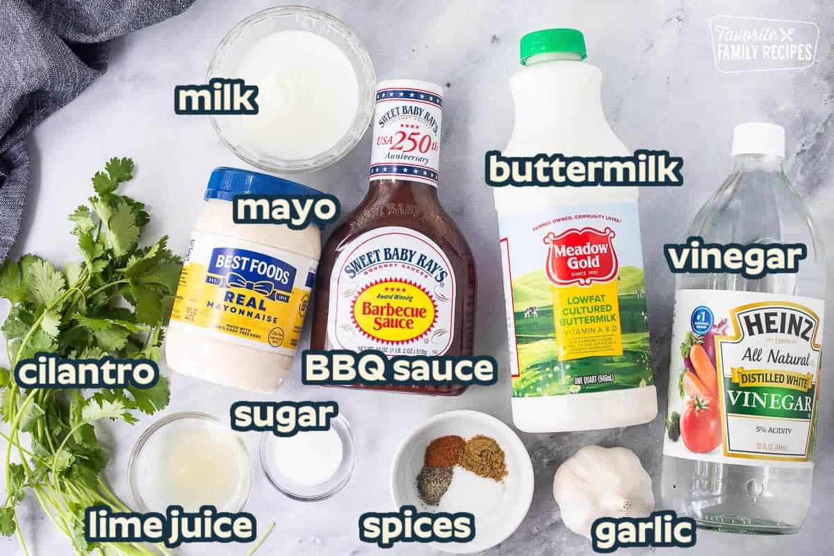 Ingredients to make BBQ chicken salad dressing including vinegar, buttermilk, garlic, salt, cumin, cayenne pepper, pepper, sugar, lime juice, cilantro, mayonnaise, milk, and barbecue sauce.