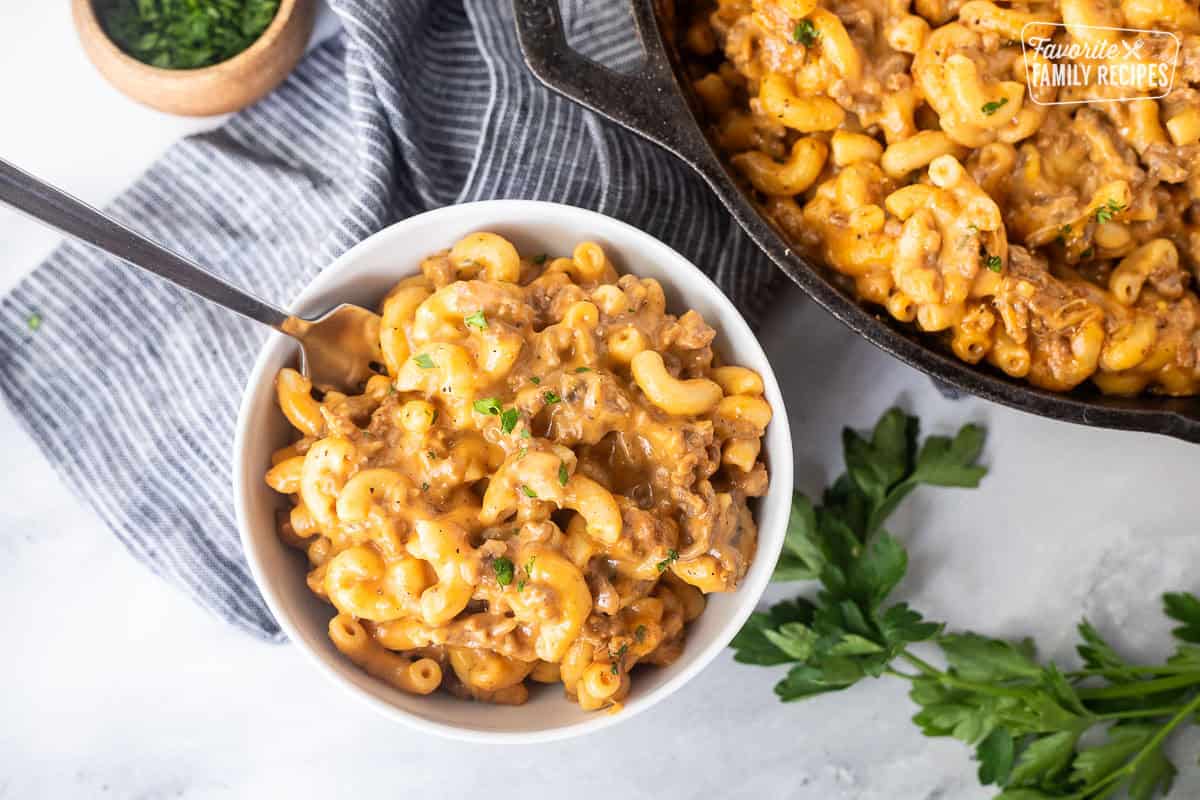 Bowl of Beefaroni with a fork next to a skillet.