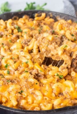 Scooping Beefaroni with a wooden spoon from a skillet.