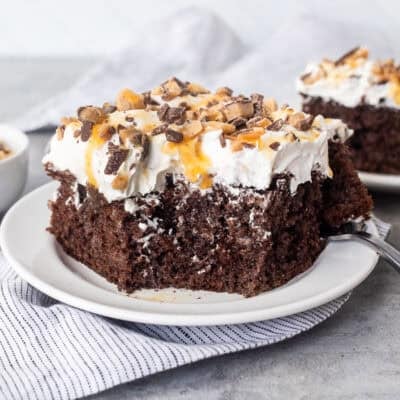 Corner missing from slice of Better Than Sex Cake on a plate with a fork.