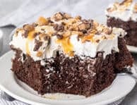 Corner missing from slice of Better Than Sex Cake on a plate with a fork.