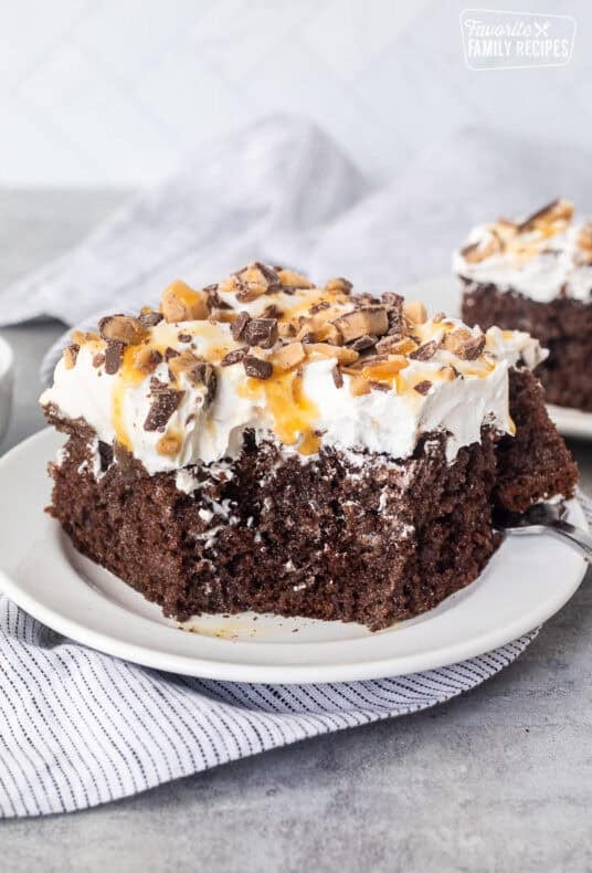Corner missing from slice of Better Than Sex Cake on a plate with a fork.