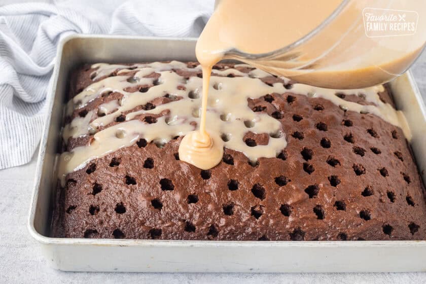 Pouring caramel sauce onto chocolate cake with holes.