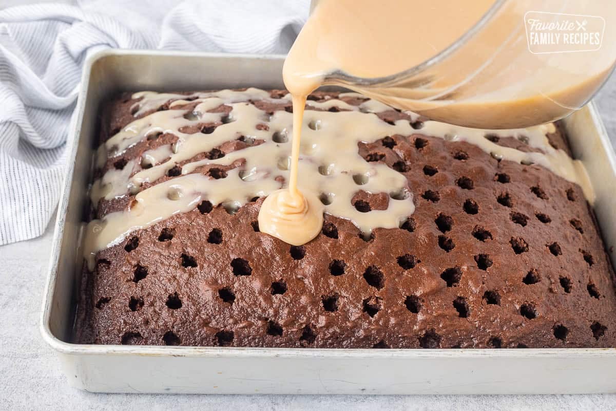 Pouring caramel sauce onto chocolate cake with holes.