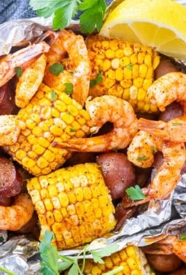 Cajun Foil Packet with shrimp, sausage, corn and red potatoes. Garnished with parsley and lemon wedges.