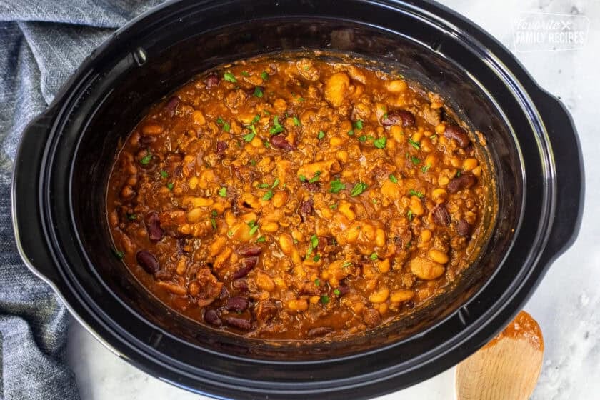 Crockpot of calico beans ground beef, bacon, pork and beans, onion, garlic, ketchup, barbecue sauce, butter beans, kidney beans, bacon, brown sugar, salt, pepper, molasses, and mustard.