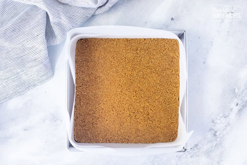 Pressed graham cracker crust on bottom of pan lined with parchment paper.