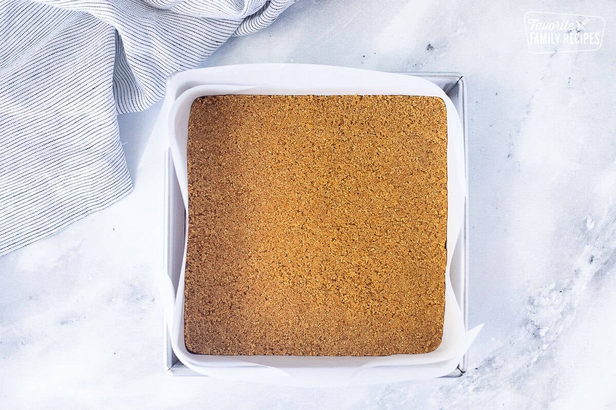 Pressed graham cracker crust on bottom of pan lined with parchment paper.