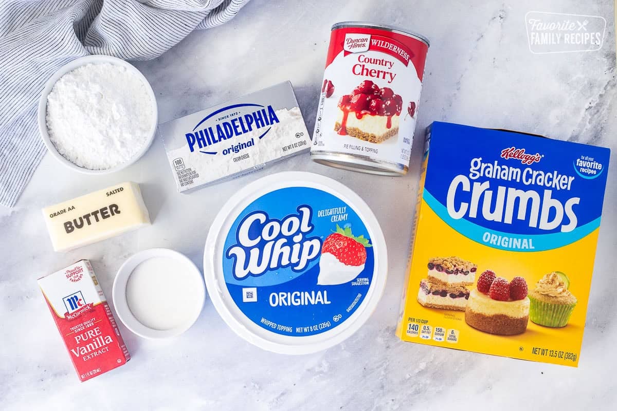 Ingredients to make Cherry Delight Recipe including graham cracker crumbs, cherry topping, cream cheese, cool whip, powdered sugar, butter, sugar and vanilla.