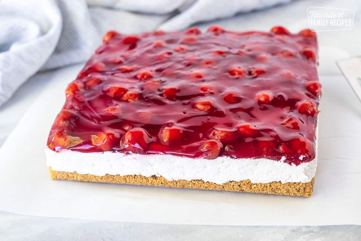 Side view of Cherry Delight out of pan on parchment paper.