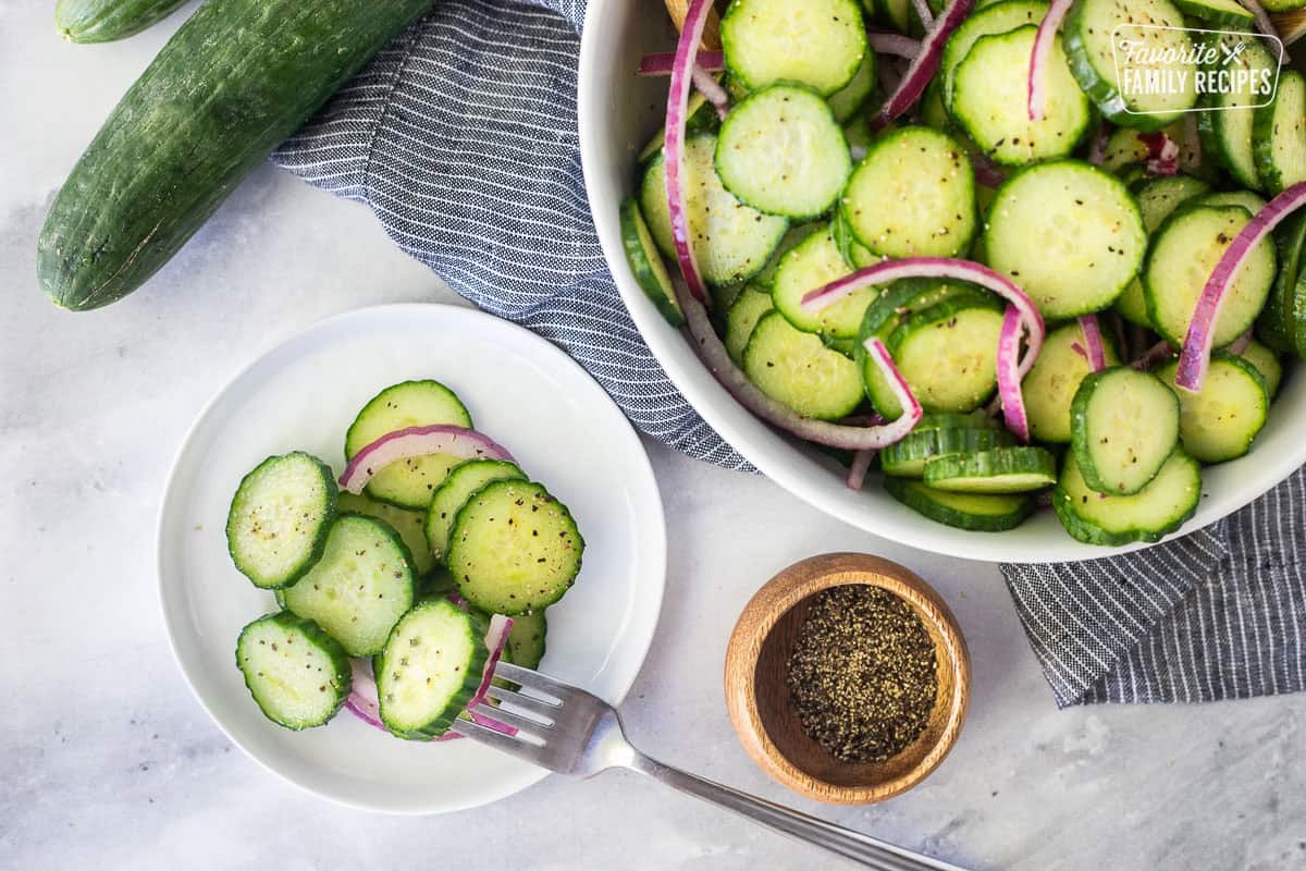 Plate of cucumber vinegar salad with sliced cucumbers and red onion.