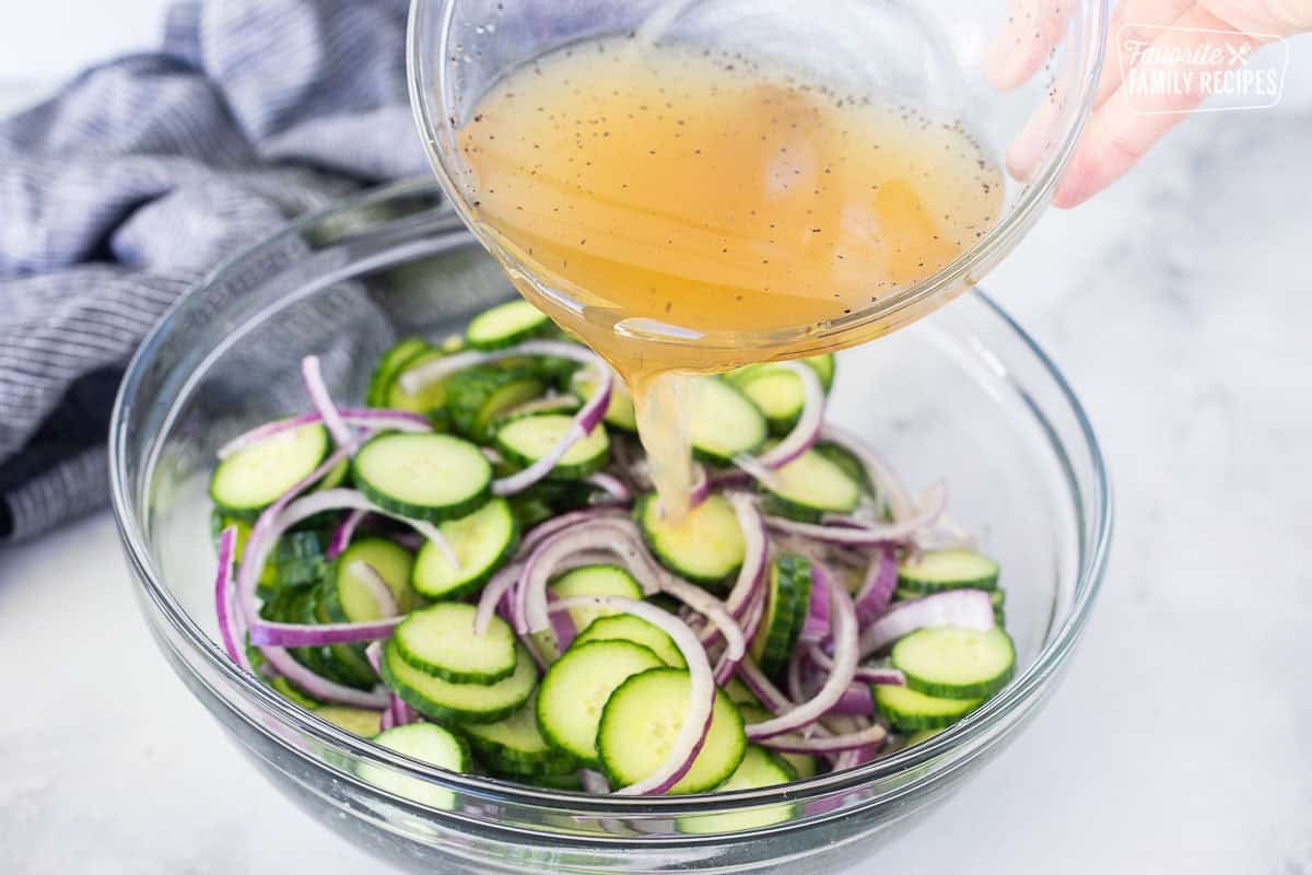 Pouring dressing on top of cucumber vinegar mix.