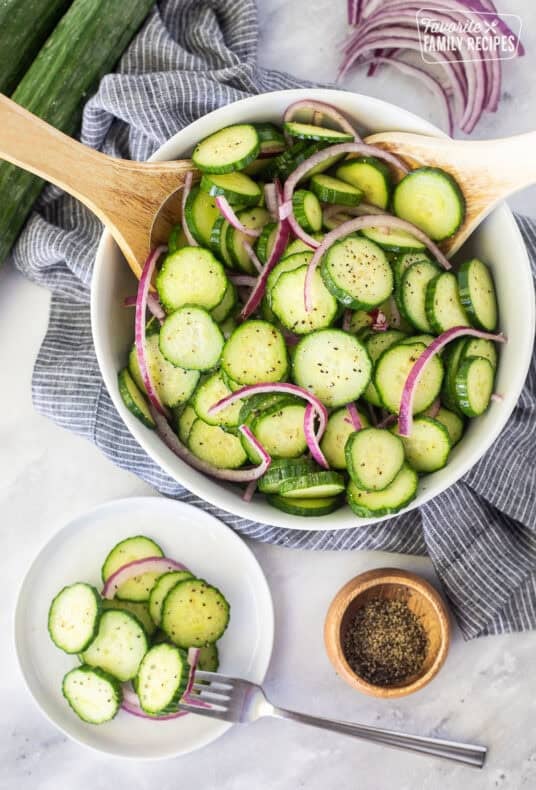 Plate of cucumber vinegar salad with sliced cucumbers and red onion.