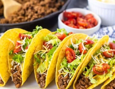 Crunchy ground beef tacos with seasoned ground beef, lettuce, cheese, and tomatoes.