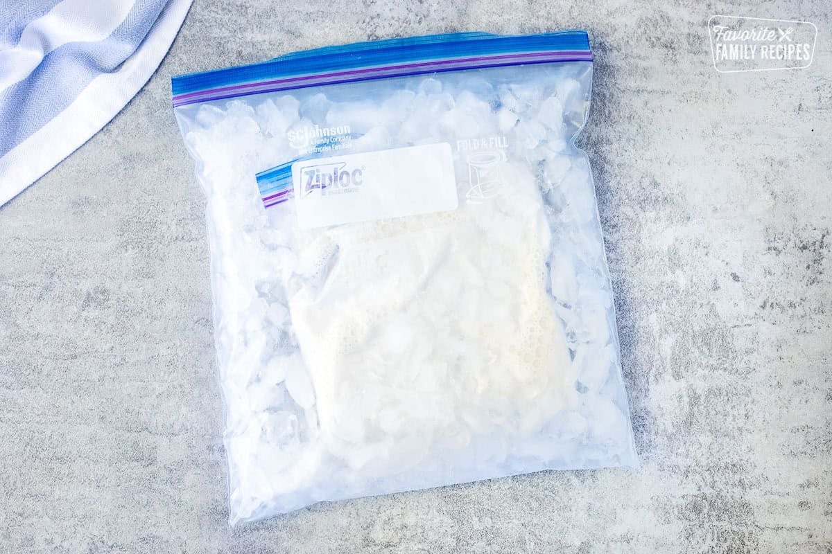 Small ice cream bag sealed into a large gallon size bag of ice and rock salt.