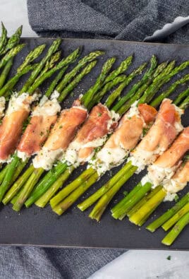 Tray with prosciutto wrapped asparagus bunches lined up.