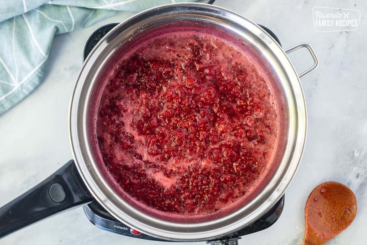 Saucepan with simmering raspberries and sugar.