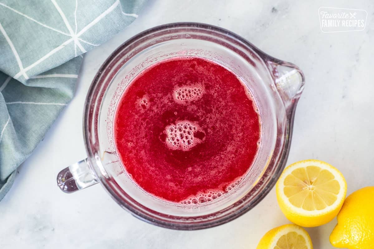 Adding lemon juice to raspberry syrup.