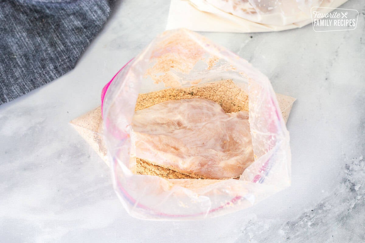 Ziplock back with bread crumb seasonings and buttermilk piece of chicken.