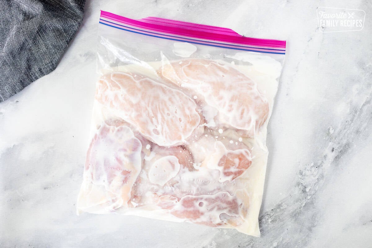 Top zip bag with buttermilk and pieces of chicken.