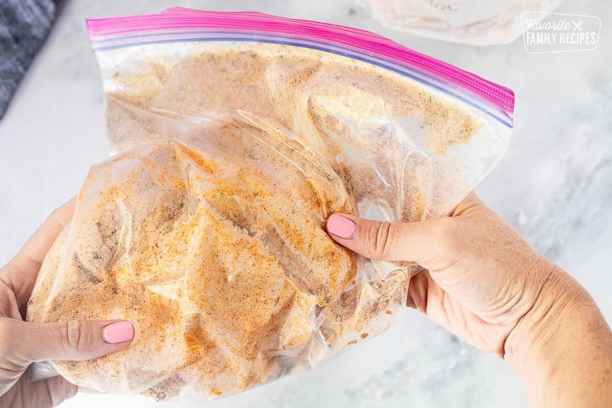 Shaking chicken piece in ziplock bag.
