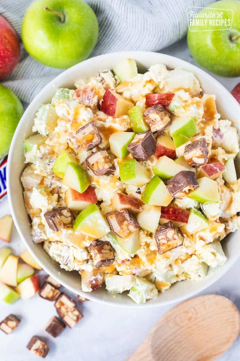 Bowl of Snickers salad topped with caramel sauce.
