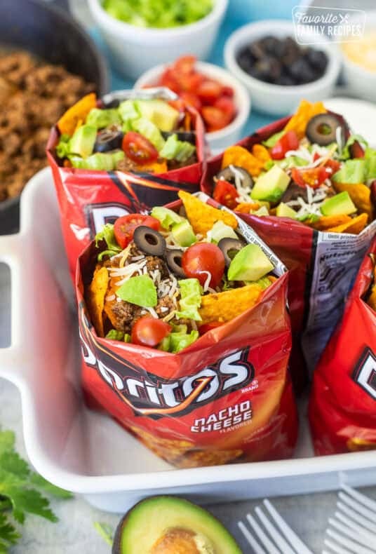 Bags of walking tacos with nacho cheese Doritos, seasoned ground beef, cheese, lettuce, tomatoes, olives and avocado.