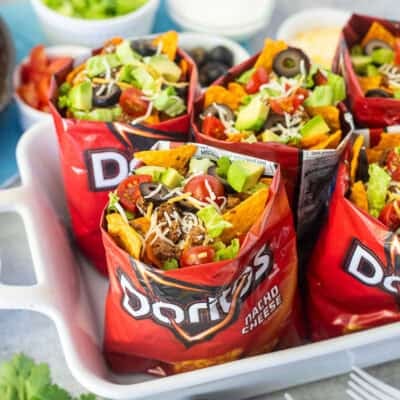Bags of walking tacos with nacho cheese Doritos, seasoned ground beef, cheese, lettuce, tomatoes, olives and avocado.